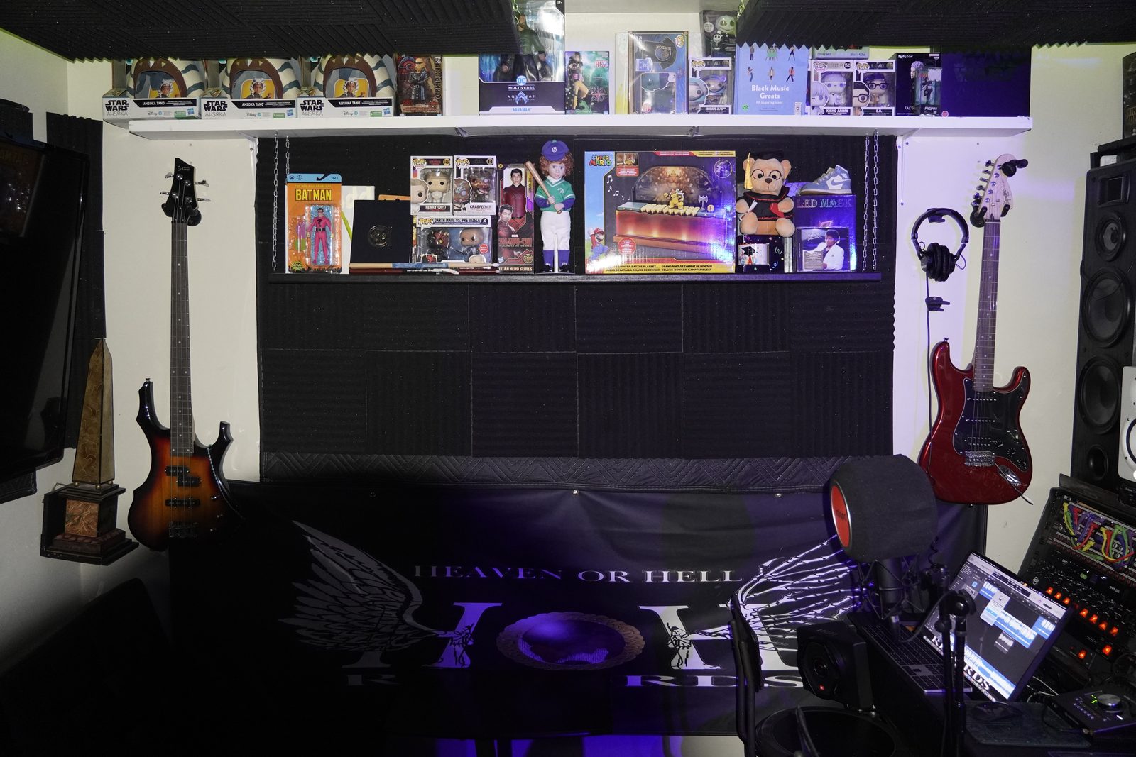 Guitars and gear wall under blue lighting